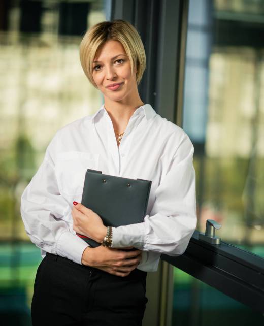 Vertical shot of a short hair blonde businesswoman folder in hand in the office A vertical shot of a short hair blonde businesswoman folder in hand in the office